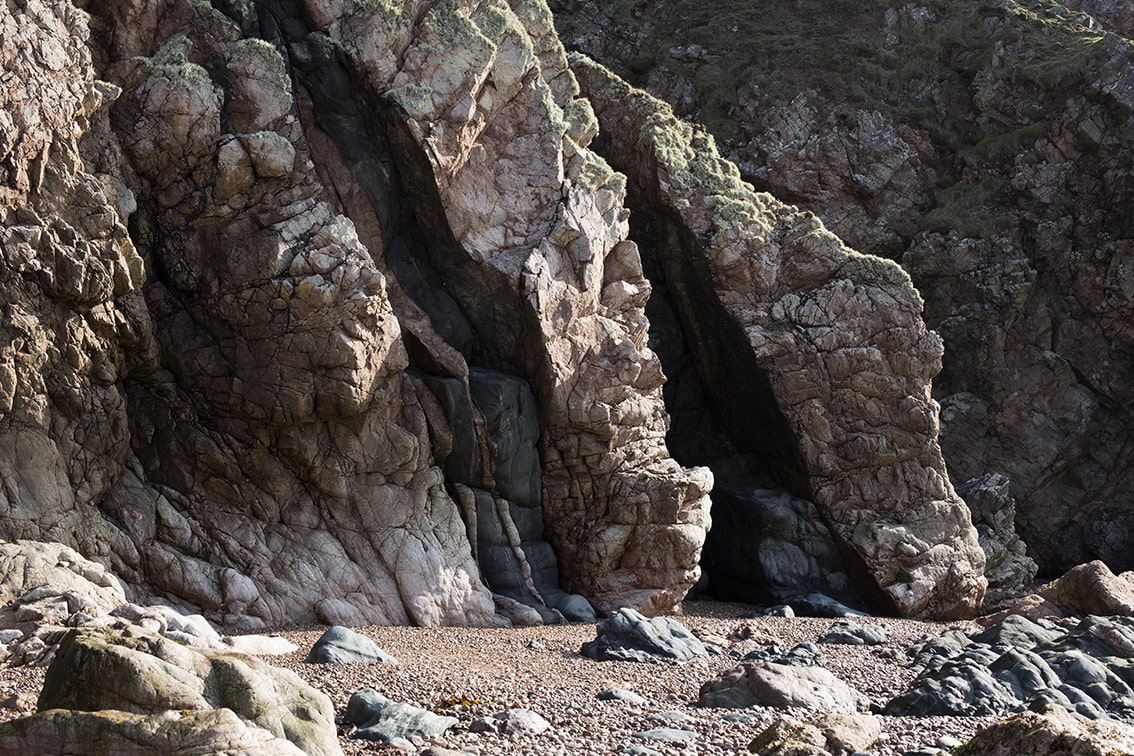 Cliff foot Hebridean beach showing an igneous intrusion of metamorphic rock