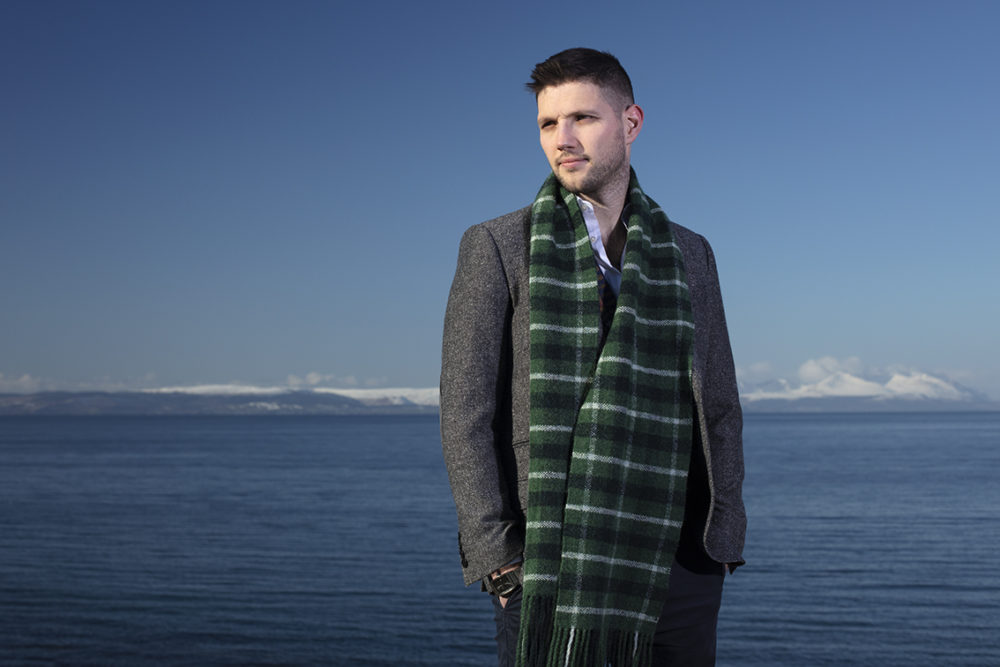 Musician Colm Keegan wearing the Rosemarkie waistcoat and a woven scarf by Alice Starmore