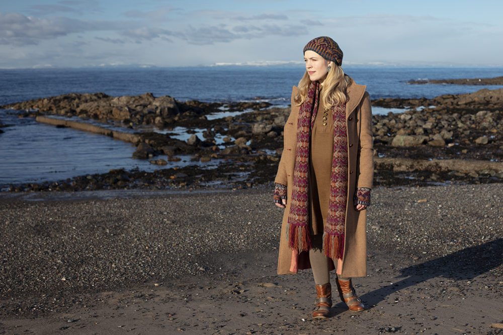 Musician Laura Durrant wearing the Lovebirds Scarf in Fireside colourway, Mary Tudor Hat and Hawk & Hound handwarmers