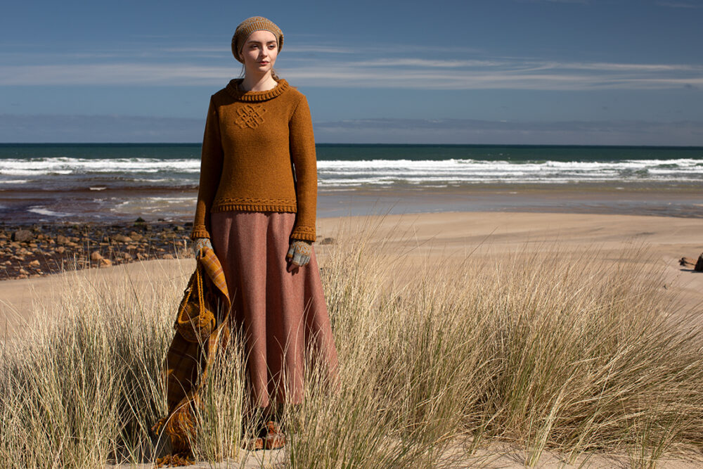 The Eightsome Reel hand knitwear patterncard kit design by Alice Starmore in Hebridean 3 Ply, worn with the Hirta Hat Set patterncard kit in Hebridean 2 ply, the Sporran Bag from Creative Course 3 and the Breacan Wrap from Woven Design Plans.
