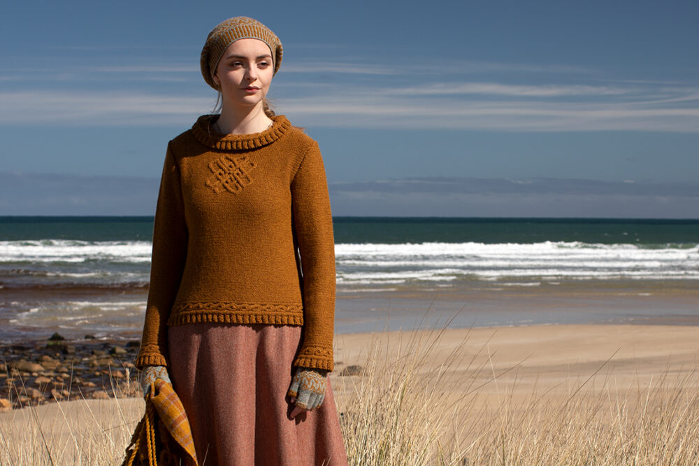 The Eightsome Reel hand knitwear patterncard kit design by Alice Starmore in Hebridean 3 Ply, worn with the Hirta Hat Set patterncard kit in Hebridean 2 ply, the Sporran Bag from Creative Course 3 and the Breacan Wrap from Woven Design Plans.