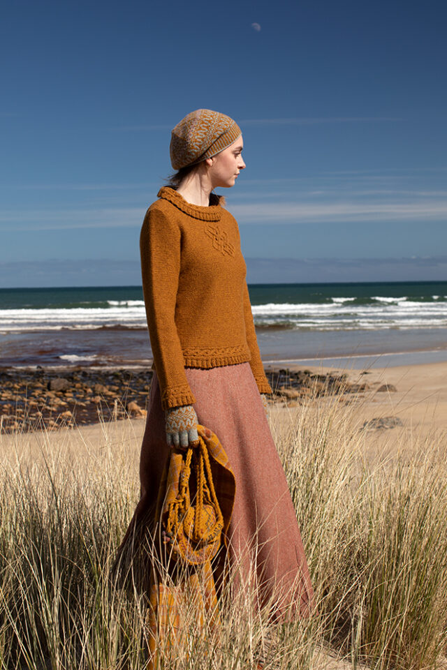 The Eightsome Reel hand knitwear patterncard kit design by Alice Starmore in Hebridean 3 Ply, worn with the Hirta Hat Set patterncard kit in Hebridean 2 ply, the Sporran Bag from Creative Course 3 and the Breacan Wrap from Woven Design Plans.
