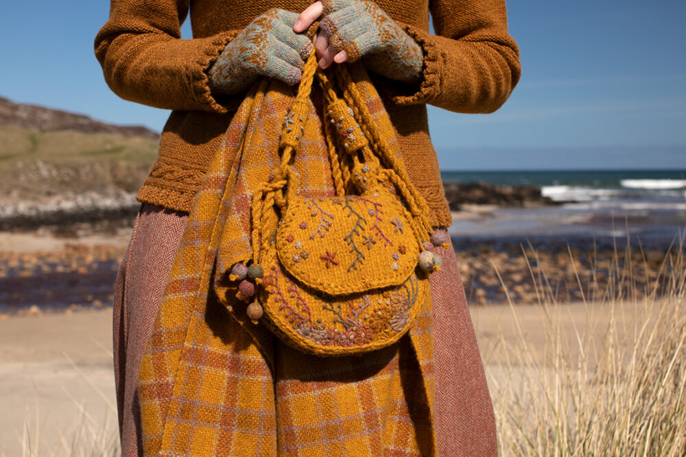 The Eightsome Reel hand knitwear patterncard kit design by Alice Starmore in Hebridean 3 Ply, worn with the Hirta Hat Set patterncard kit in Hebridean 2 ply, the Sporran Bag from Creative Course 3 and the Breacan Wrap from Woven Design Plans.